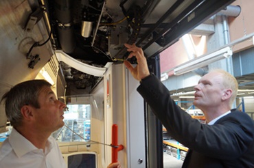 El técnico del sistema VAG Robert Meier y el experto de igus Werner Pecher prueban una puerta con cables chainflex® y cadena portacables.